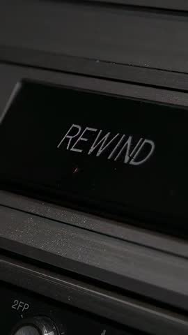 Finger Pressing REWIND Button on Vintage Tape Deck Rewinding Cassette Close-Up Vertical Video