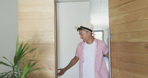 Playful Young Man in Straw Hat Peeking Behind Door - Download Free Stock Images Pikwizard.com