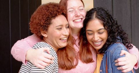 Diverse Female Friends Embracing Joyfully on Porch