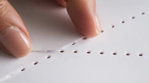 Close-up video showing fingertips peeling perforated paper strip along tear line
