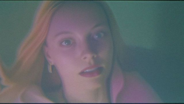 Elegant female in pastel light with pink collar and gold earrings