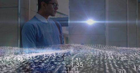 Standing professional viewing holographic data visualization and analytics in glass lobby