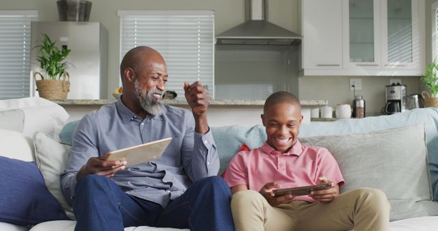 Happy African American Father and Son Playing with Tablets at Home - Download Free Stock Images Pikwizard.com