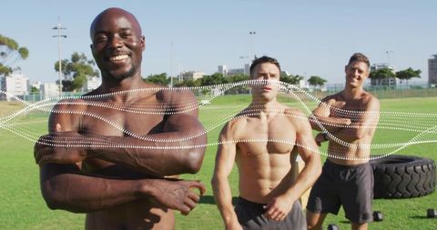 Outdoor fitness trio training with tire and dumbbells on sunny sports field