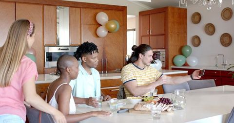 Friends Capturing Moments During Joyful Home Gathering