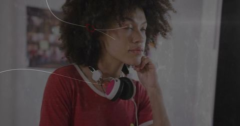 Young Woman Reflecting with Headphones in Creative Studio