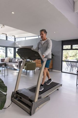 Senior Man Staying Active with Home Treadmill Exercise