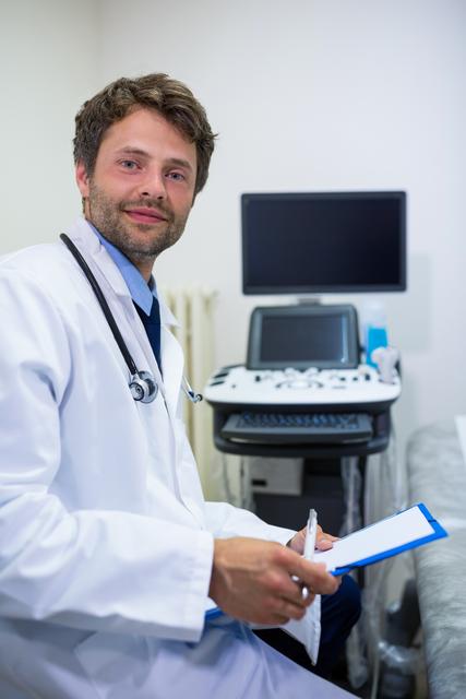 Portrait of smiling doctor holding clipboard at the hospital