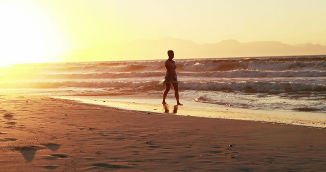 Woman Walking on Beach at Sunset with Gentle Waves - Download Free Stock Images Pikwizard.com