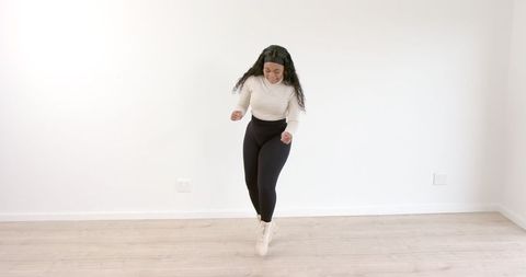 Woman Dancing Energetically in Minimalist Living Room