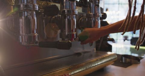 Barista brewing espresso with professional machine in cozy cafe