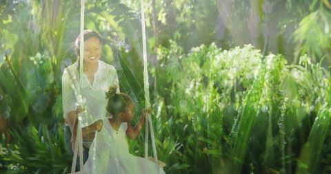 Cheerful Mother with Daughter on Swing in Vibrant Garden - Download Free Stock Images Pikwizard.com