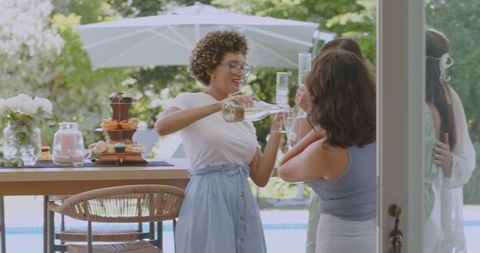 Celebration Outdoors, Smiling Woman Pouring Champagne with Friends