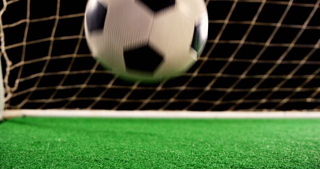 Image capturing thrilling moment of soccer ball scoring a goal. Perfect for sports event promotions, soccer-related advertisements, sports blog articles, and educational materials celebrating football success.