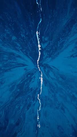 Flowing white streak sliding down deep blue marbled panel, vertical abstract fluid motion