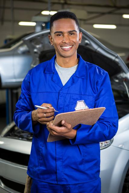 Portrait of happy mechanic preparing a check list at repair garage