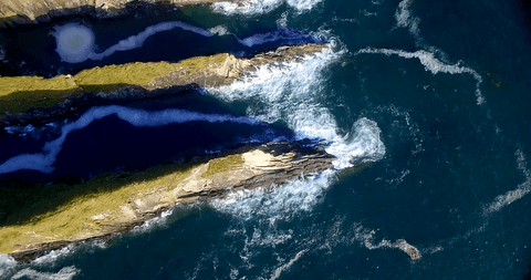 aerial view over rocky sea coastline with transparent waves - Download Free Stock Videos Pikwizard.com