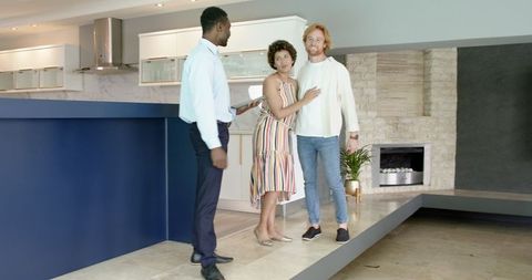 Friendly Real Estate Agent Guides Happy Couple on House Tour