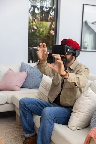 Man Wearing VR Headset in Modern Living Room, Experiencing Virtual Reality