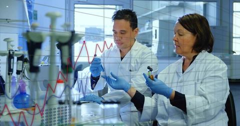 Senior Scientist Mentoring Trainee Pipetting at Lab Bench with Graph and Data Overlay