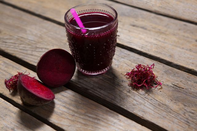 Close-up of beetroot juice and slice of beetroot on wooden table