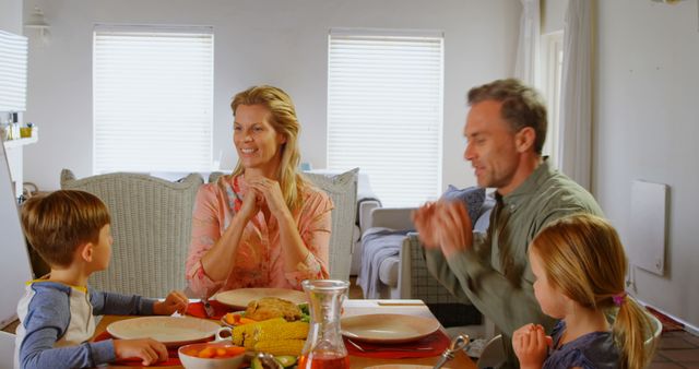 Front view of young Caucasian family having food at dining table in a comfortable home. They are praying together 4k