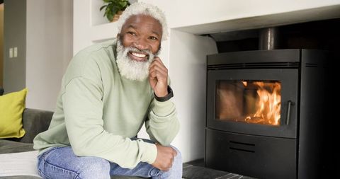 Senior Man Enjoying Coziness by Glowing Wood Stove
