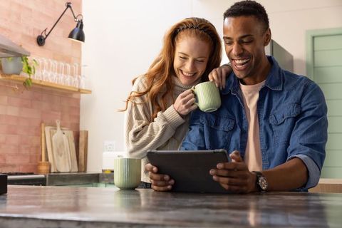 Smiling Couple Enjoying Tablet Time in Cozy Kitchen