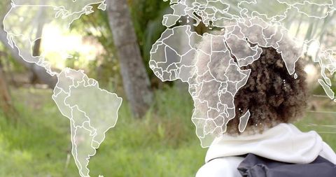 Backpack traveler exploring world map overlay in sunlit forest and meadow for travel planning