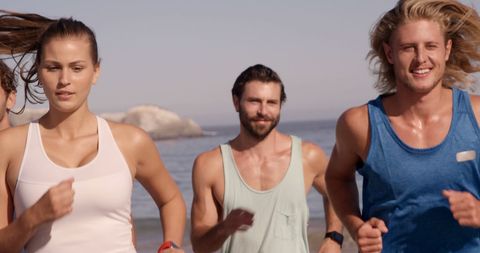Young adults jogging on scenic beach promoting fitness
