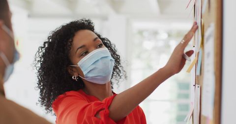 Business Meeting with Masked Professionals Engaging with Charts