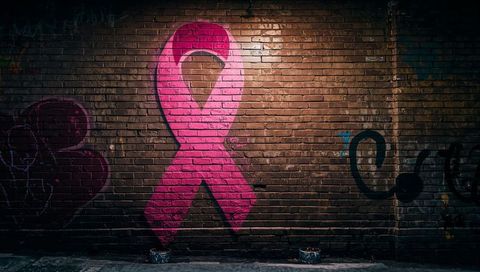 Vibrant Pink Ribbon Graffiti Mural on Urban Brick Wall