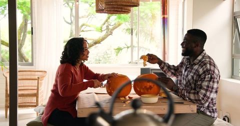 Couple Carving Pumpkins Enjoying Halloween Tradition Together