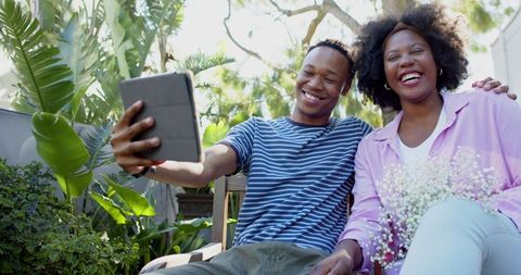 Smiling Couple Taking Selfie Outdoors in Relaxing Garden