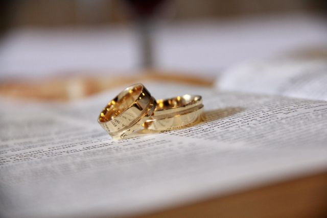 Golden wedding rings lying on the open pages of a book symbolize love and commitment. This can be used in wedding invitations, engagement announcements, romantic articles, and blogs. Ideal for promoting jewelry, showcasing romantic themes, and celebrating marriage.