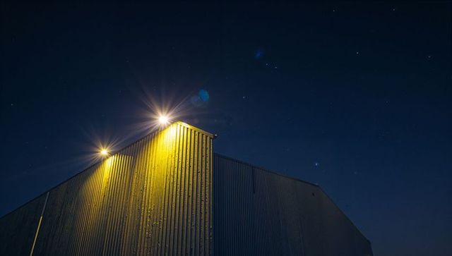 Industrial building illuminated by yellow spotlights at night