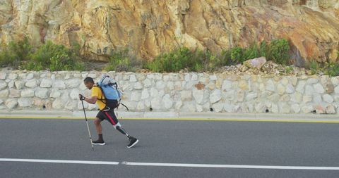 Determined Hiker with Prosthetic Leg Walking on Mountain Road
