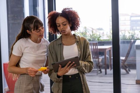 Diverse Female Coworkers Collaborating Outdoors with Tablet