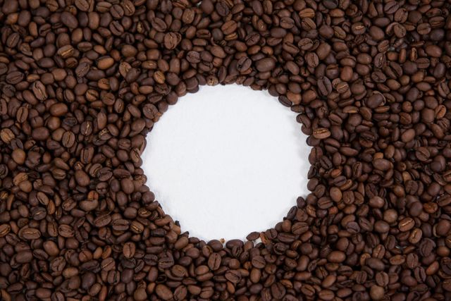Coffee beans forming circle shape on white background