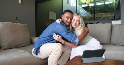 Happy couple announcing engagement via video call on tablet