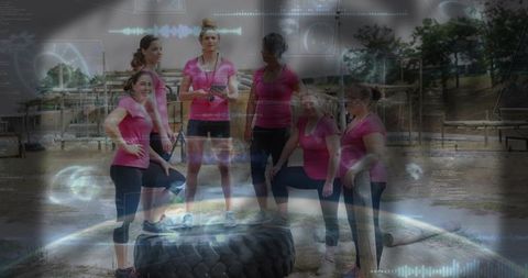 Women rallying in outdoor bootcamp around tractor tire while coach using phone to track training