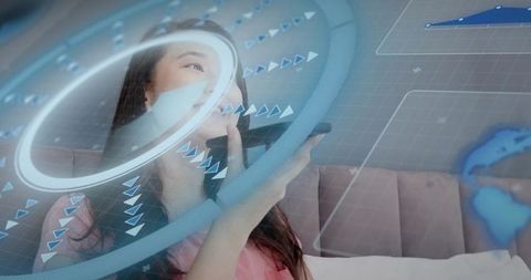 Asian woman speaking into smartphone while holding device, holographic AR UI futuristic