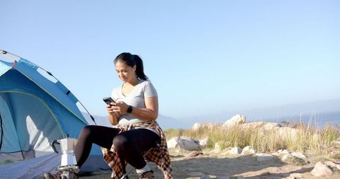 Woman Enjoying Smartphone Break in Mountain Camp