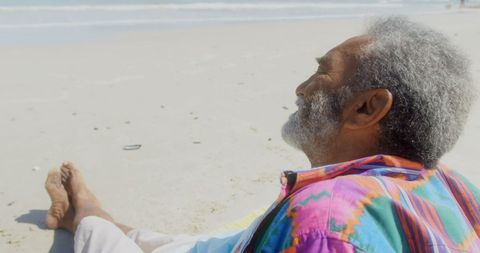 Thoughtful Senior Man Relaxing on Sunny Beachside Morning