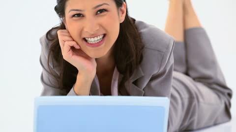 Businesswoman Smiling and Using Laptop with Relaxed Confidence