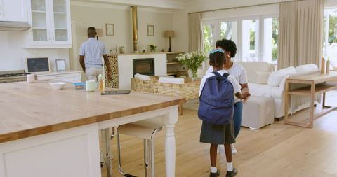 Parents helping children prepare for first day of school at home