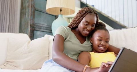 Mother and Daughter Bonding with Tablet, Smiling at Home