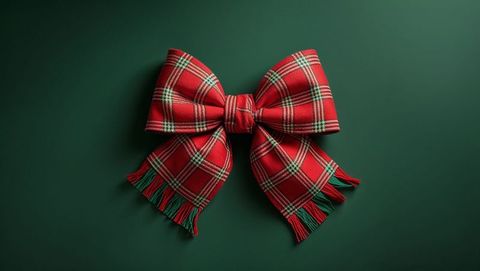 Festive tartan plaid bow on dark green surface