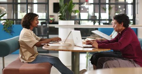African American Colleagues Collaborating Around Round Table in Modern Coworking Space