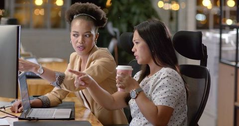 Colleagues Collaborating with Laptop and Coffee in Professional Office